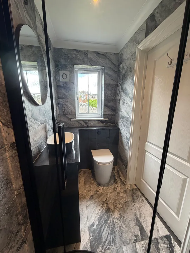 Marble-effect WC with black furniture and tiled floor